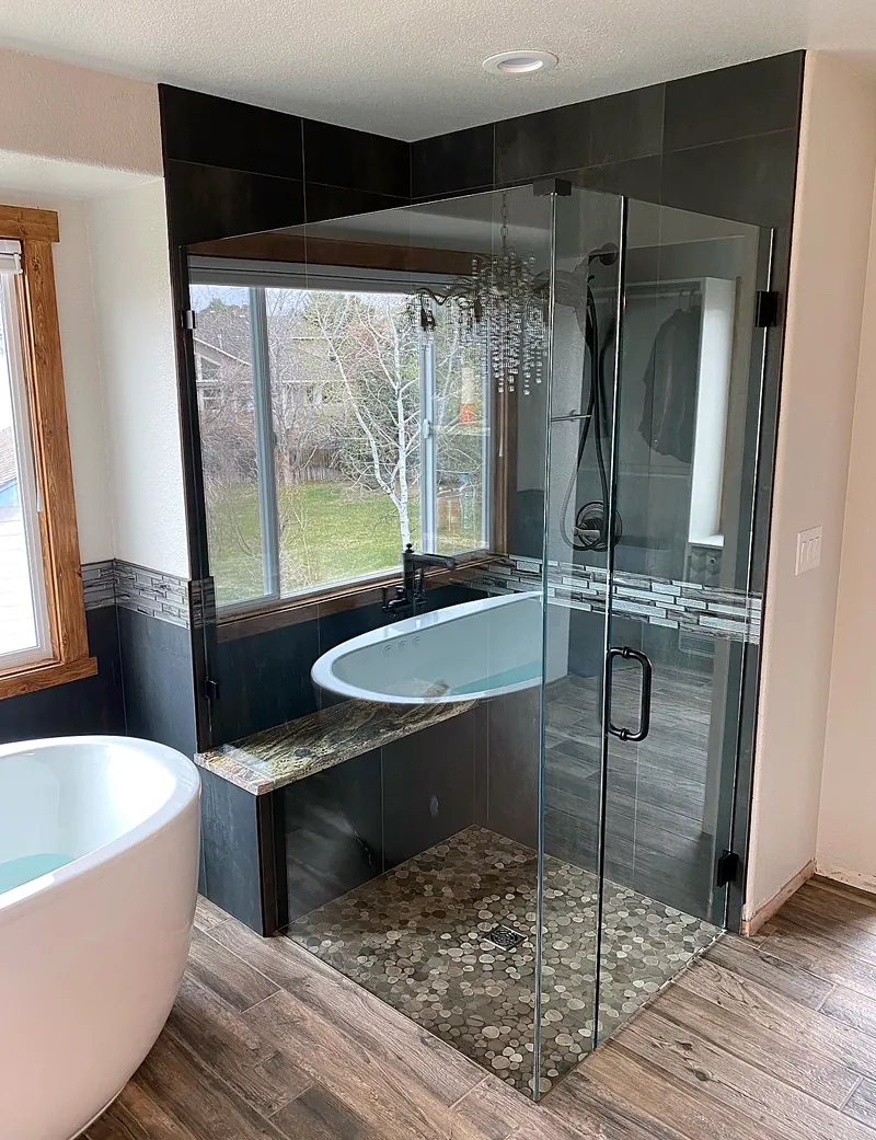 Black tile shower: pebble floor and stone bench