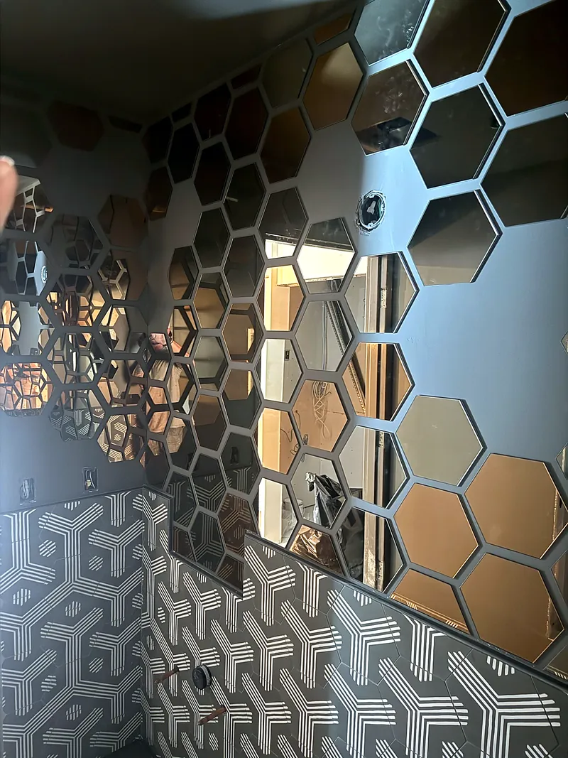 Commercial restroom: hexagon mirror mosaic over patterned tile